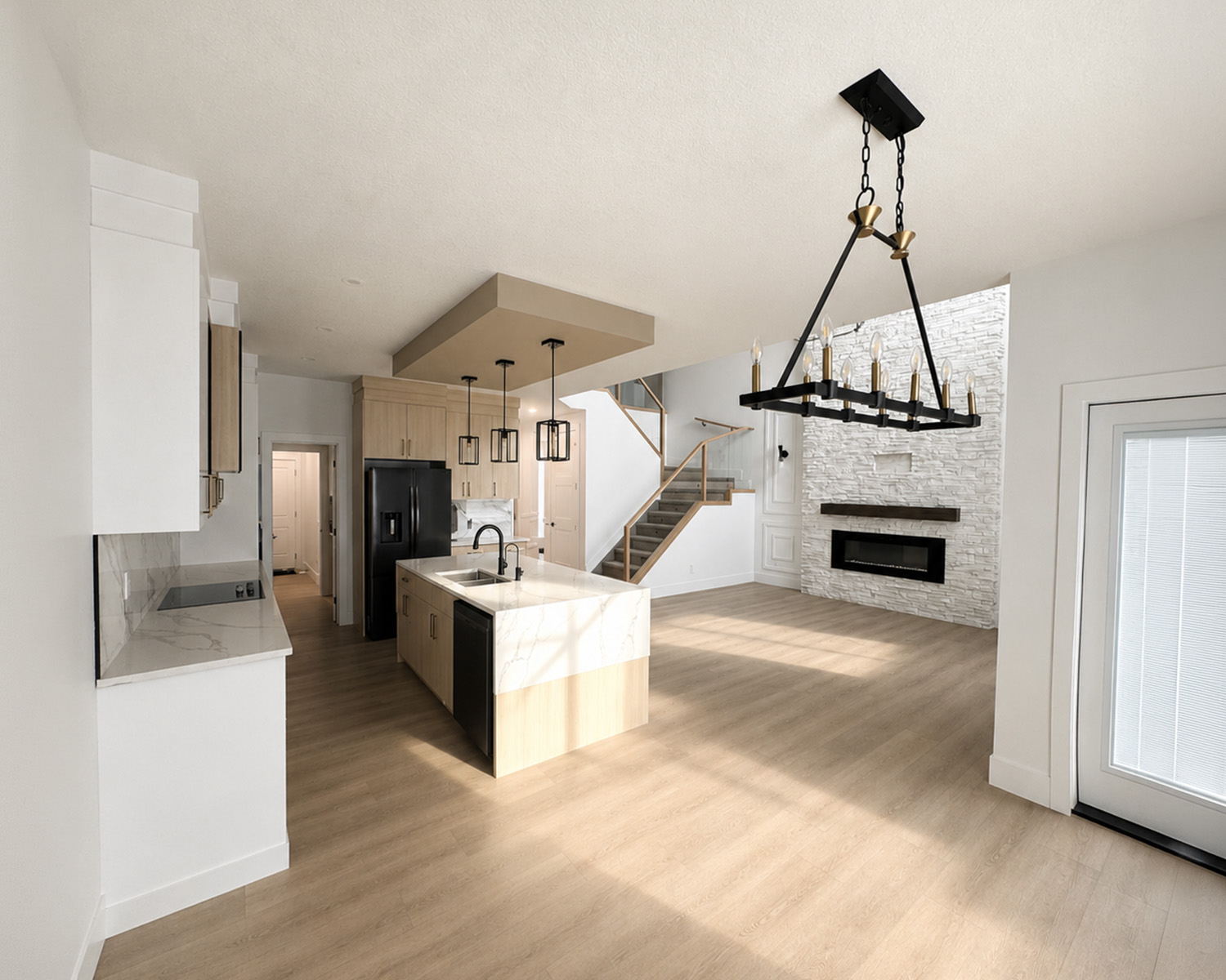 A brightly lit new home image featuring a view of the kitchen and living room.
